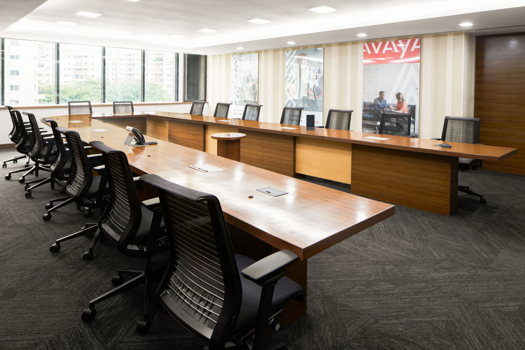 Large meeting room with wood-toned tables and Avaya signage.