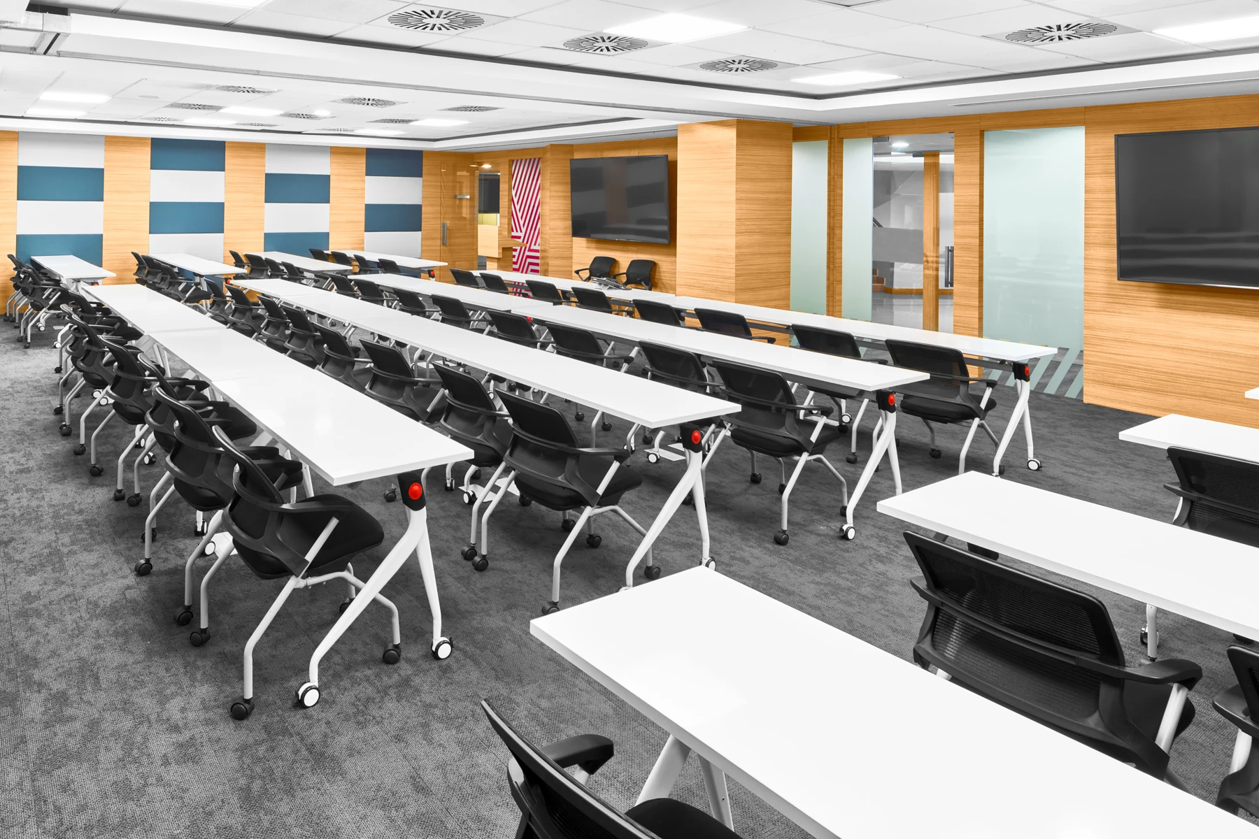 Training room with rows of tables facing a presentation wall.