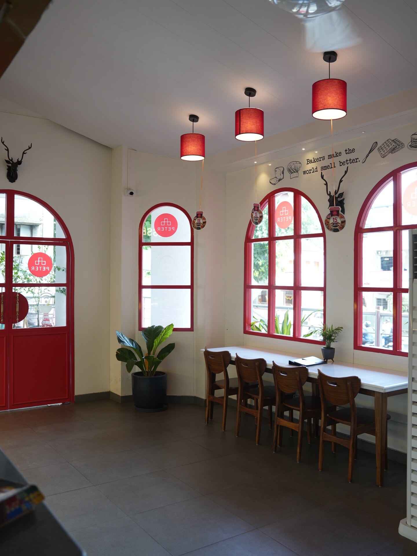 Red-framed arched dining area inside Café Peter, Erandwane, Pune — a completed prāngaṇa hospitality interior.
