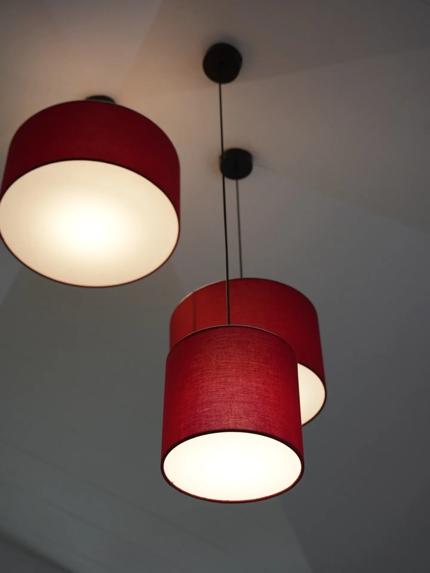 Red cylindrical pendant lighting detail in Café Peter Erandwane Pune — hospitality interior by prāngaṇa.