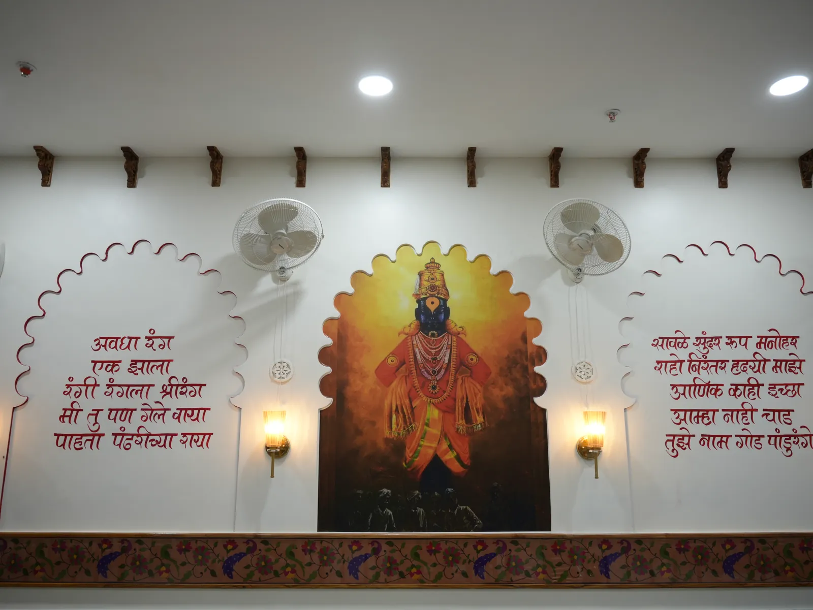 Devotional wall artwork, Marathi lettering and warm lamps at Purnabramha.