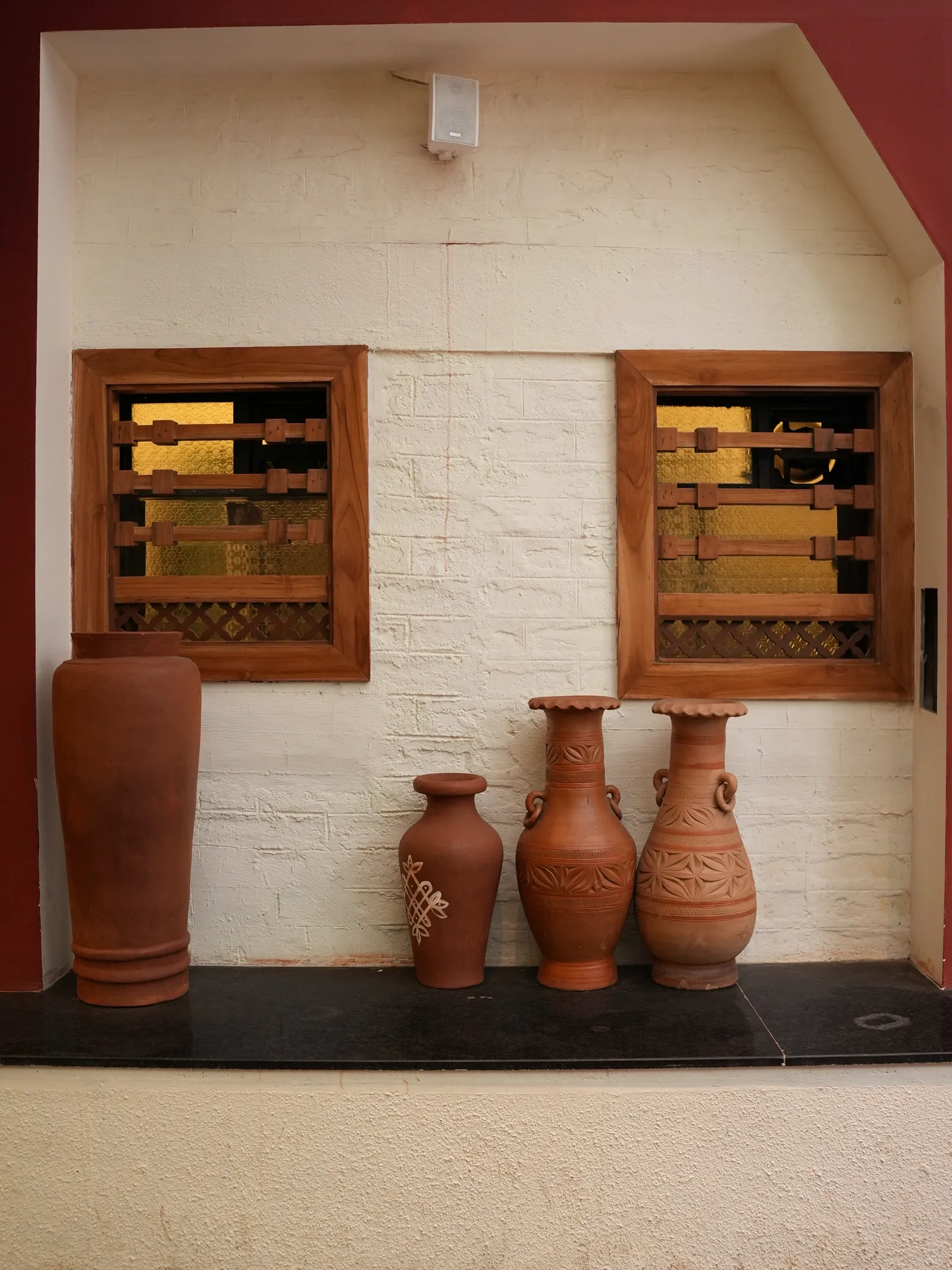 Decorative earthen pots beneath timber-framed windows at Secret Sambar.