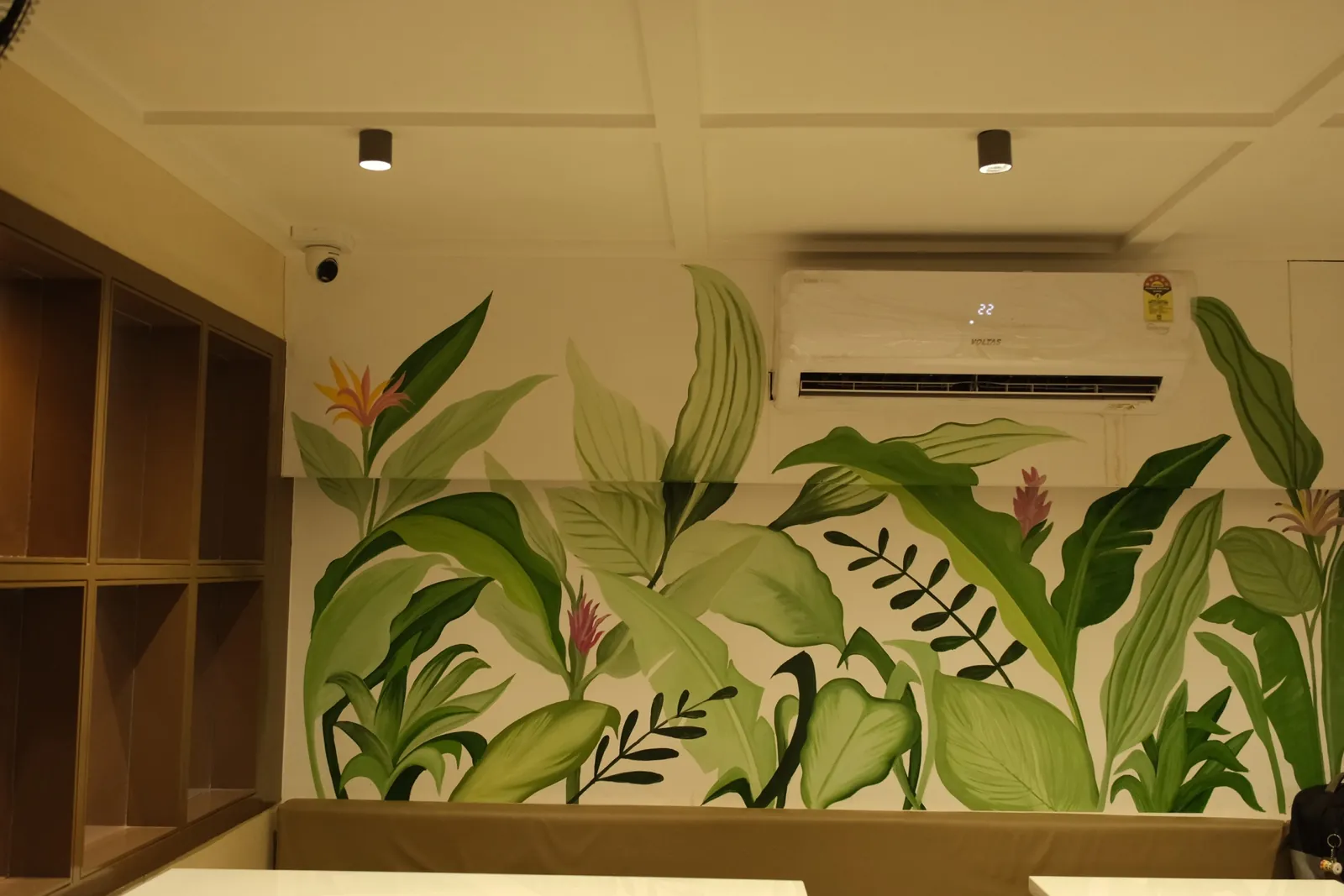 Painted botanical mural at Street Coffee BVP Pune — detailed wall illustration as seating backdrop.