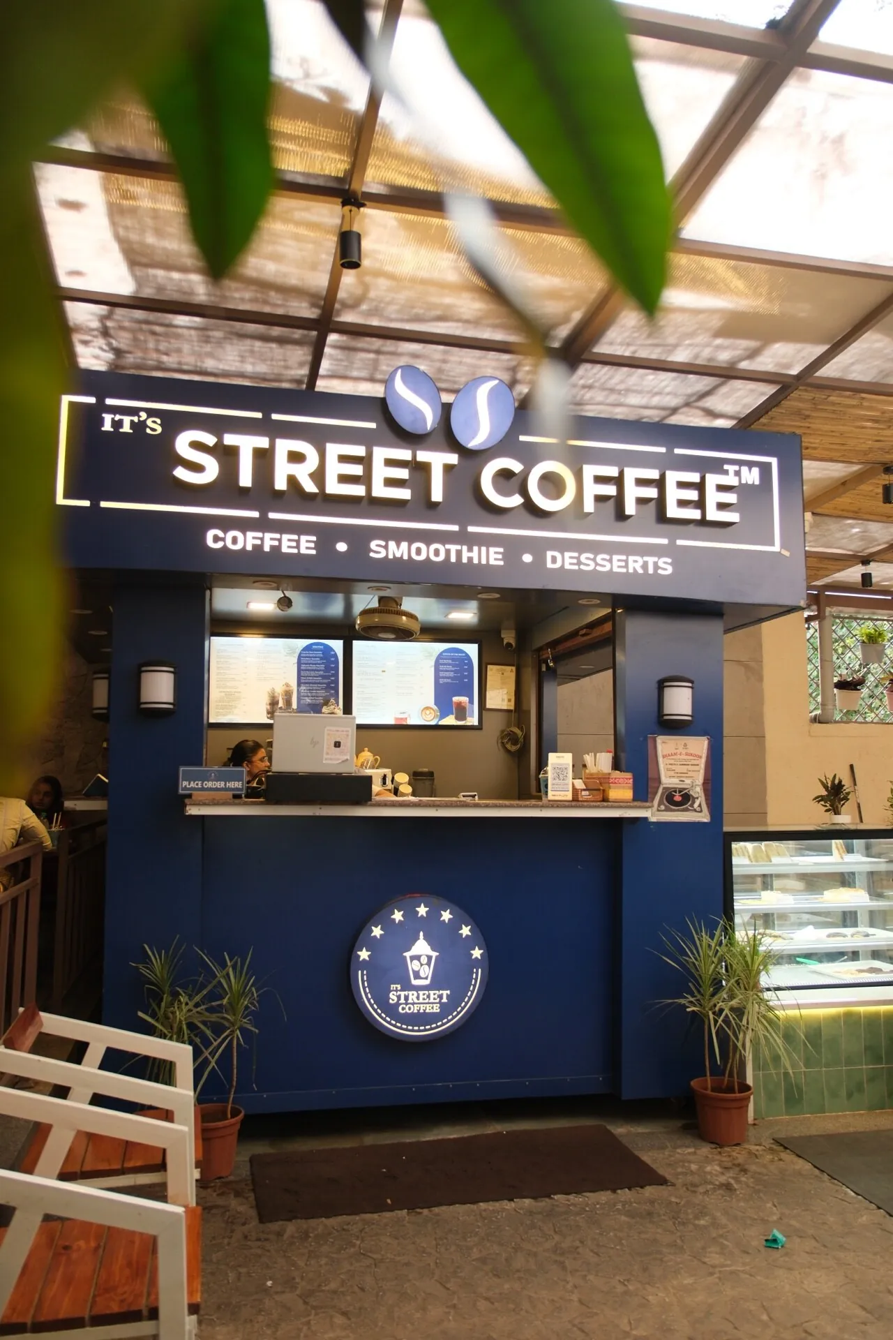 Street Coffee BVP Pune — blue service counter with cafe signage and canopy detailing. Interior by prāngaṇa.