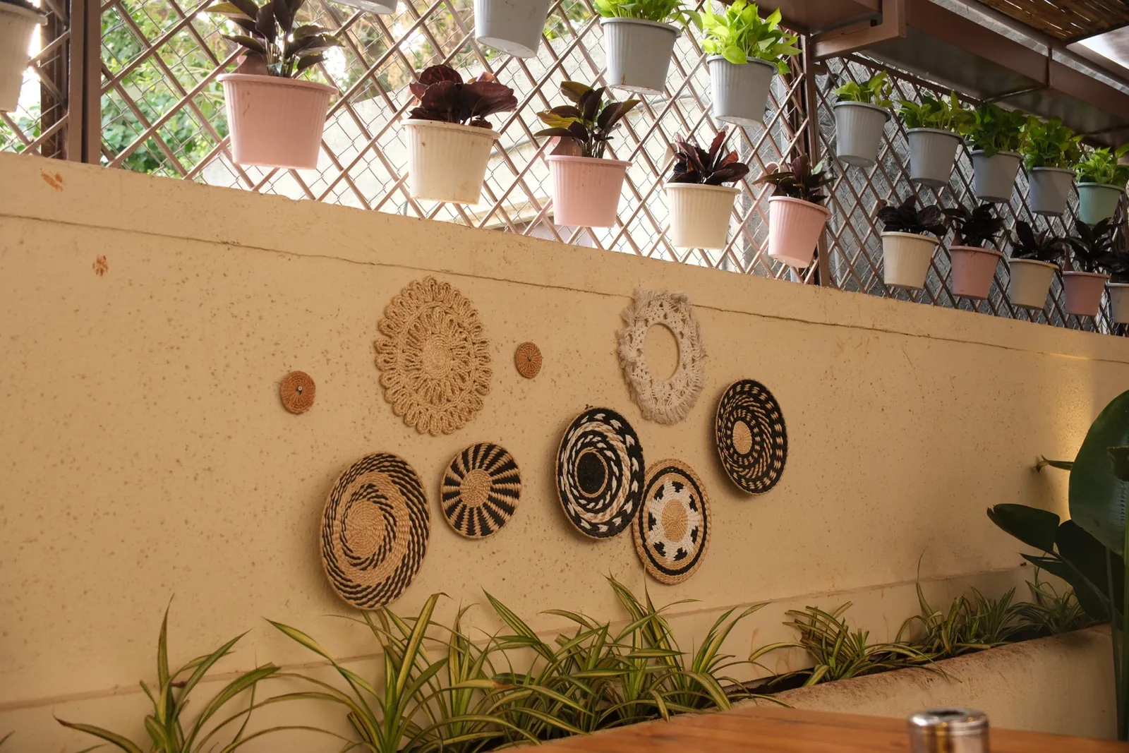 Decorative wall with planters and woven plates at Street Coffee BVP Pune — interior by prāngaṇa.